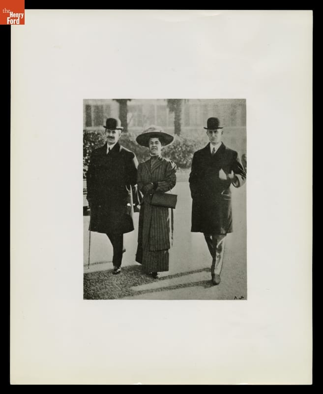 Orville Wright, Katharine Wright and Wilbur Wright in France, 1909 Matted photograph of woman in dress and hat walking between two men in coats and bowlers
