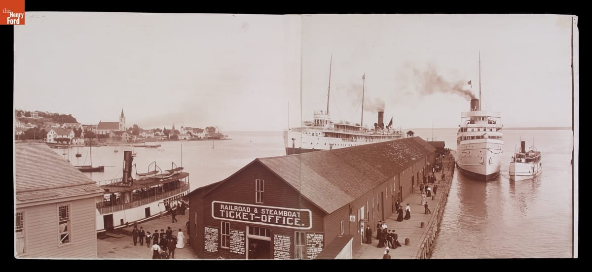 Mission Point and Arnold Dock, Mackinac Island, Michigan, circa 1905 Black-and-white image of dock with long low building on it and several large ships in the water around it
