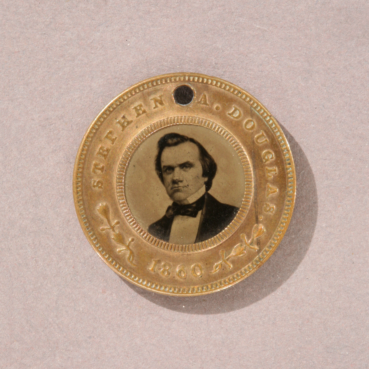 Round gold token with image of man’s shoulders and head in the middle and text “Stephen Douglas 1860” around edge