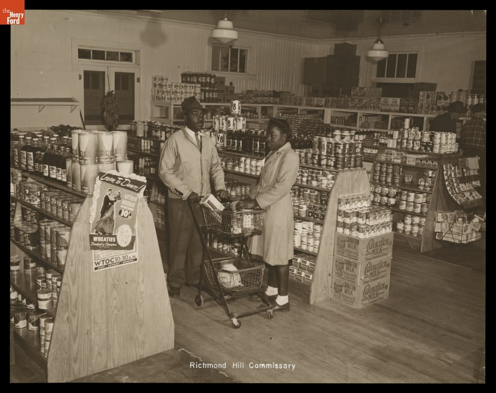Interior of Commissary, Richmond Hill, Georgia, circa 1947 Two people stand by a grocery cart in a room filled with shelves stocked with canned goods; other shoppers are nearby