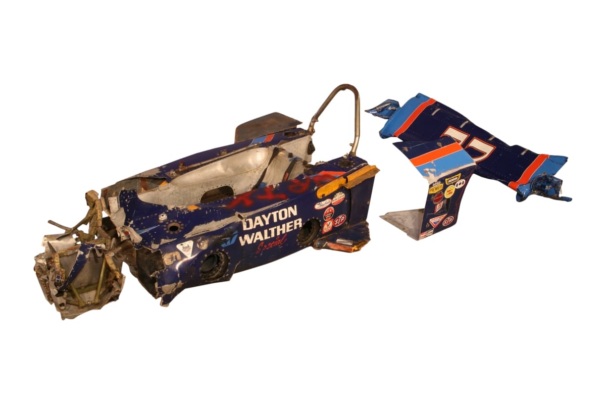 Mangled body and pieces of a blue race car