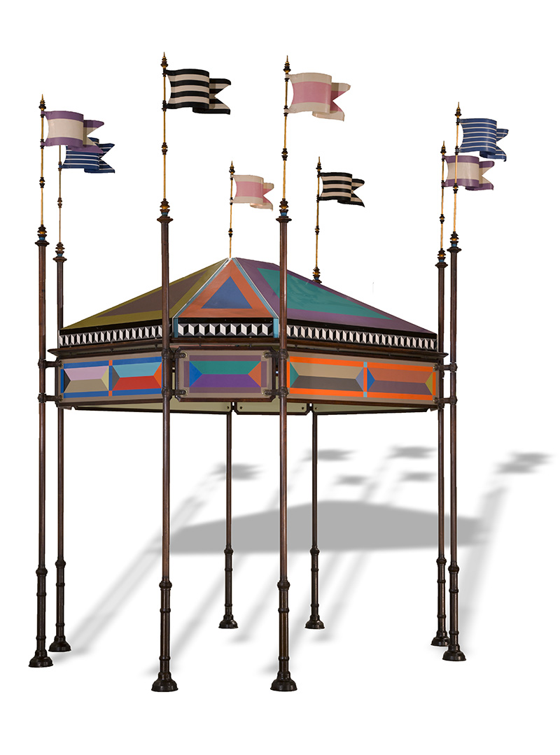 Colorful tent-like structure with thin poles supporting a colorful roof and topped with flags