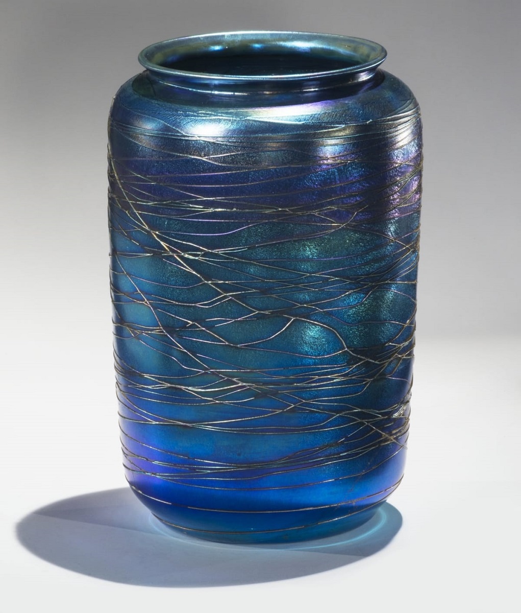 Wide blue glass vase with straight sides and wide opening, with pattern of lines running around it