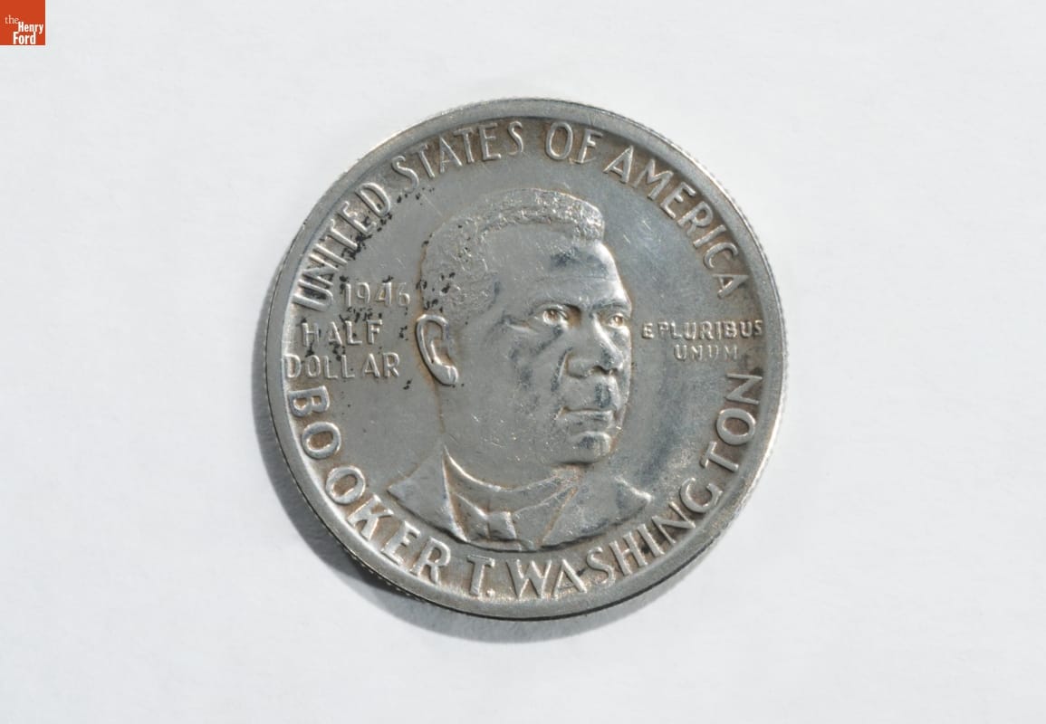 Silver coin with text and image of man's face