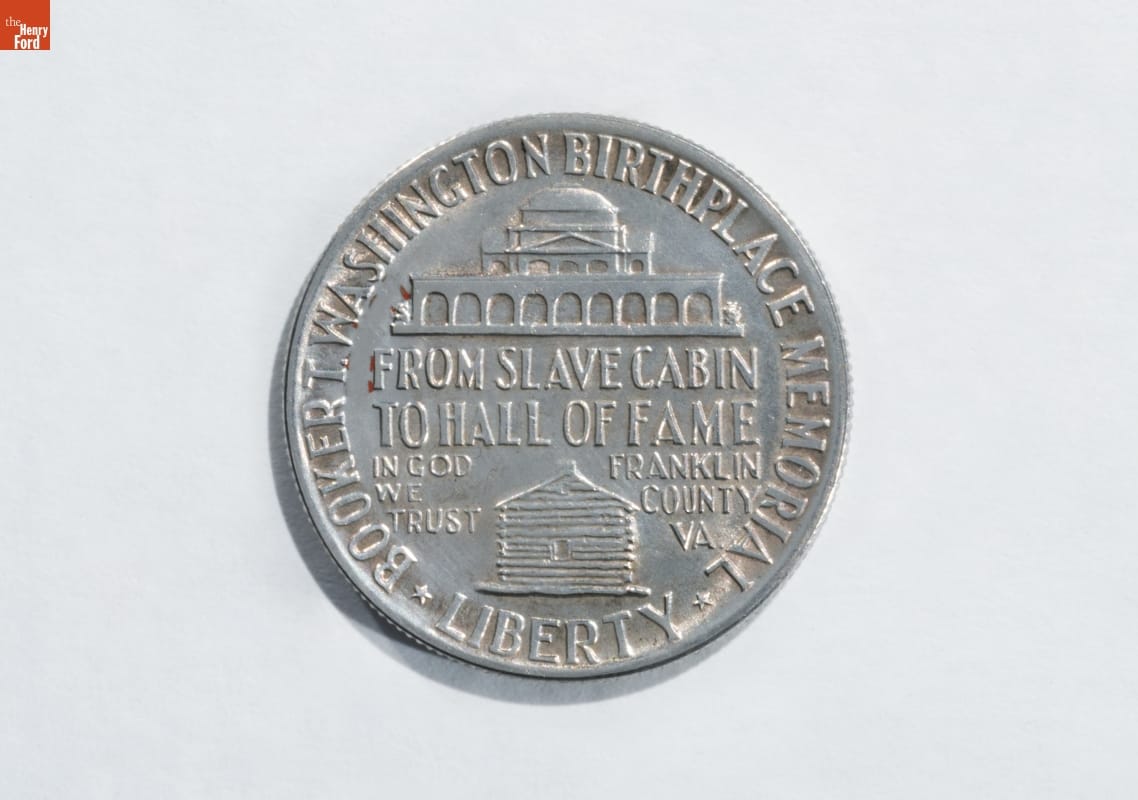 Silver coin with text and images of two buildings