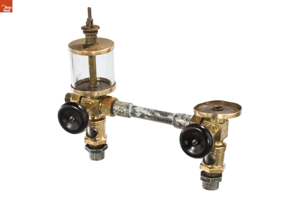 Lubricator Cup Assembly Piece of equipment with metal and brass fittings and black knobs
