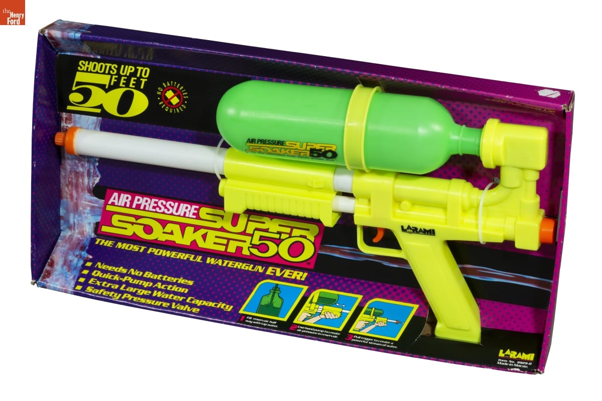 Super Soaker 50 Water Gun, 1991-1992 Large yellow and green water gun in black and purple cardboard packaging; also contains text