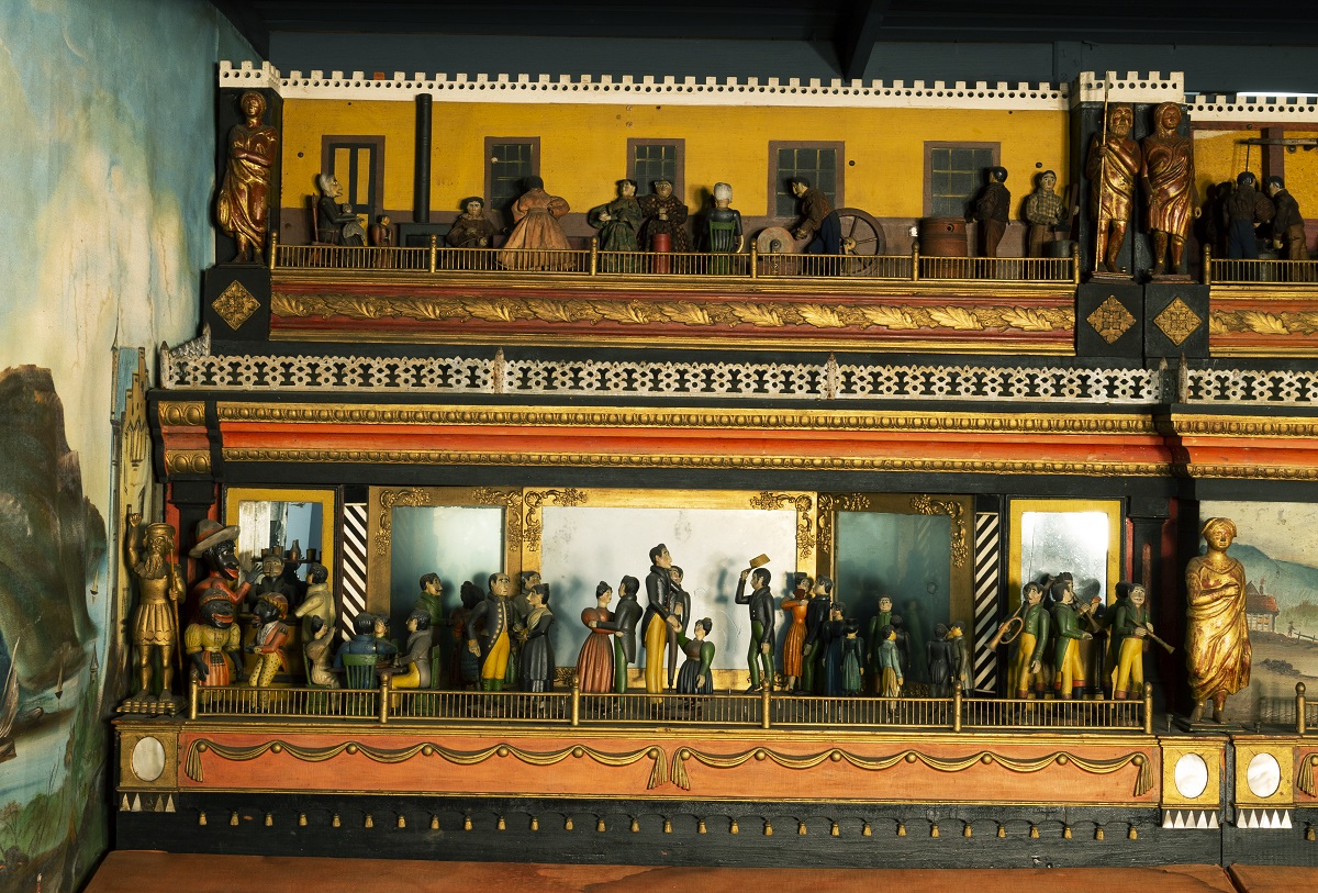 Wooden platform with two carved scenes with human figures, one above the other