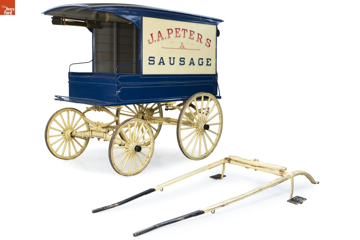 J.A. Peters Sausage Delivery Wagon, 1908-1912 Royal blue wagon with white wheels and large white sign on side reading "J.A. Peters Sausage"