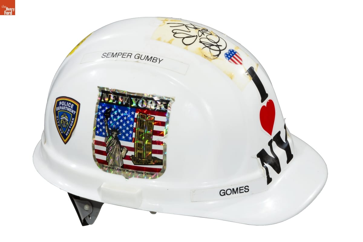 White hard hat with text, decals, and handwriting on it