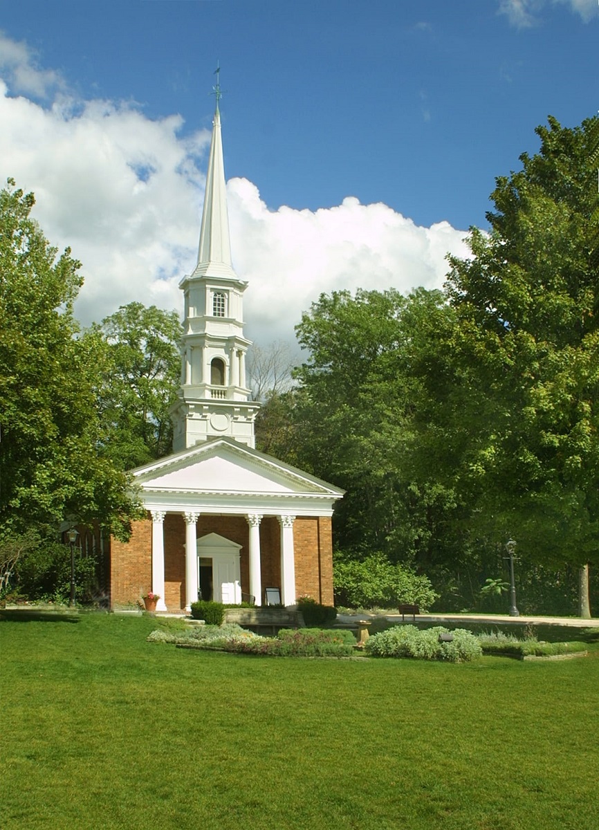 Red brick and white wood building with columns out front and steeple