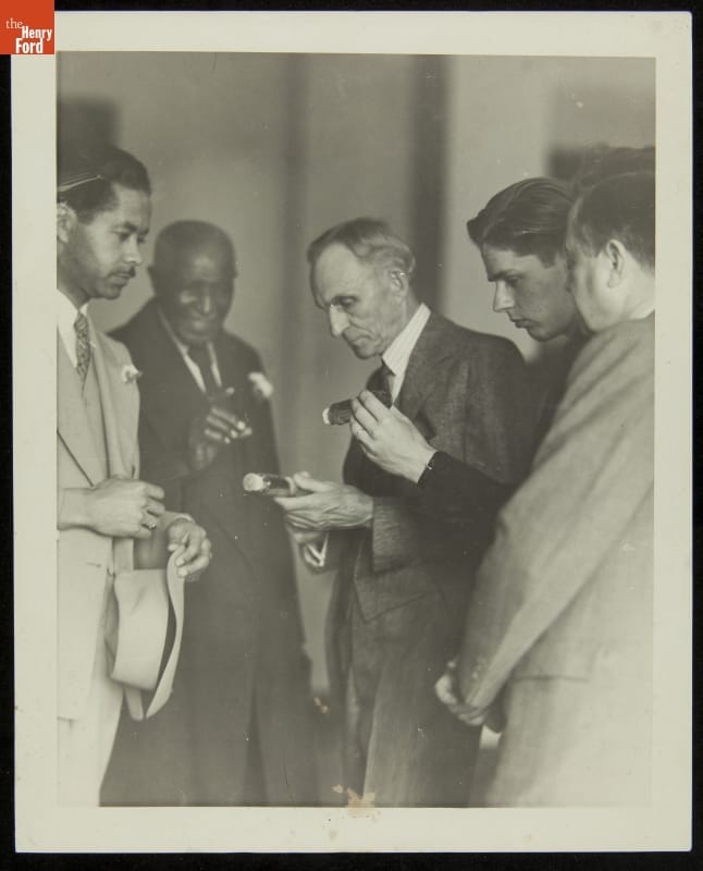 Austin Curtis, George Washington Carver, Henry Ford, Wilbur Donaldson and Frank Campsall Inspect Peanut Oil, Tuskegee Institute, March 1938 Five men in suits look at items some of them are holding in their hands