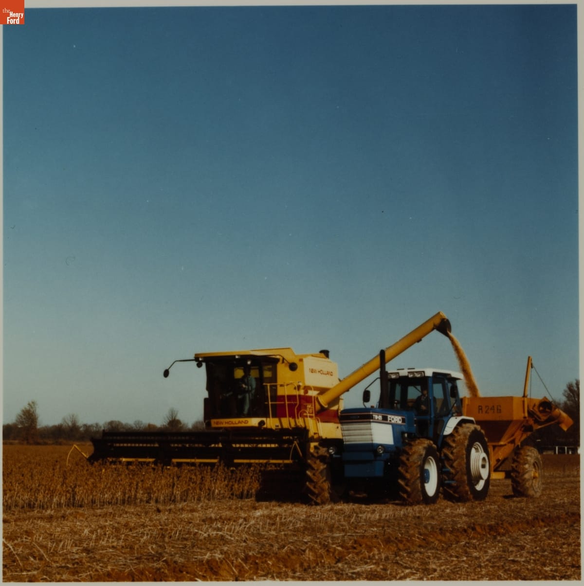 Large blue and yellow piece of agricultural equipment harvesting crops in a field 