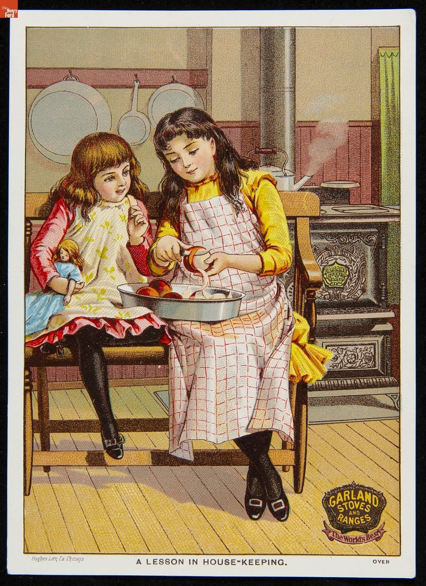 Two girls sit on a bench in front of a stove; one pares an apple into a pan