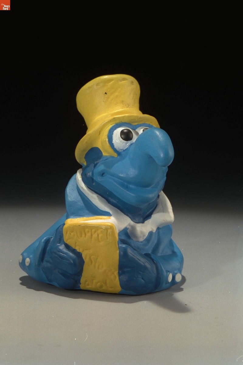 Gonzo, Muppet Christmas Carol Kids' Meal Toys, 1993 Blue creature with hooked nose, wearing yellow top hat and holding a yellow book