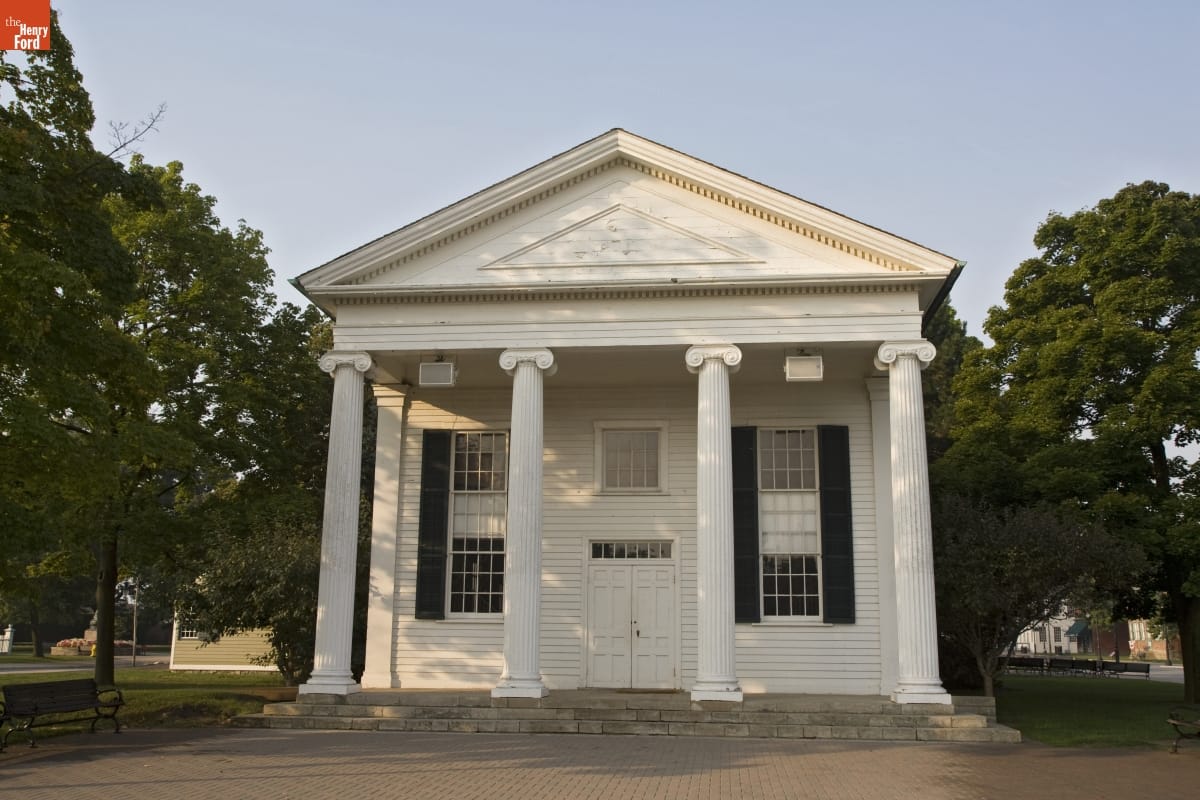 White wooden building with four large columns in front