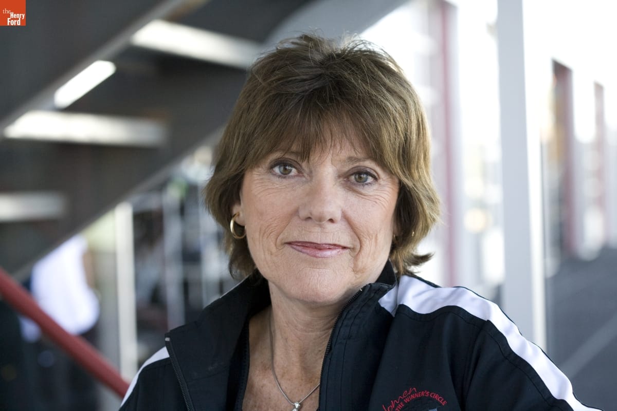 Lyn St. James, photographed by Michelle Andonian, 2008 Woman with short brown hair wearing track jacket smiles toward camera
