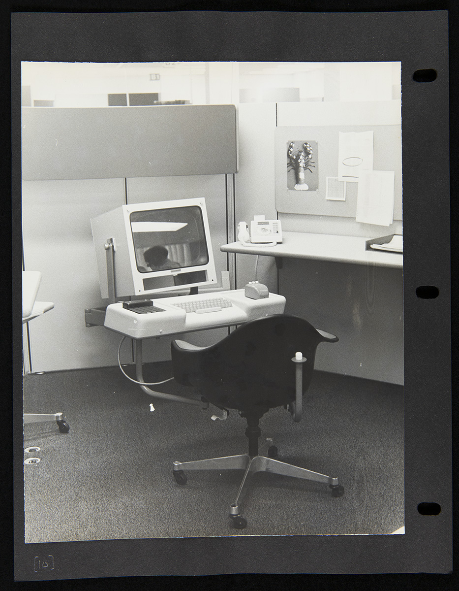 Office cubicle with chair in front of computer with large boxy monitor