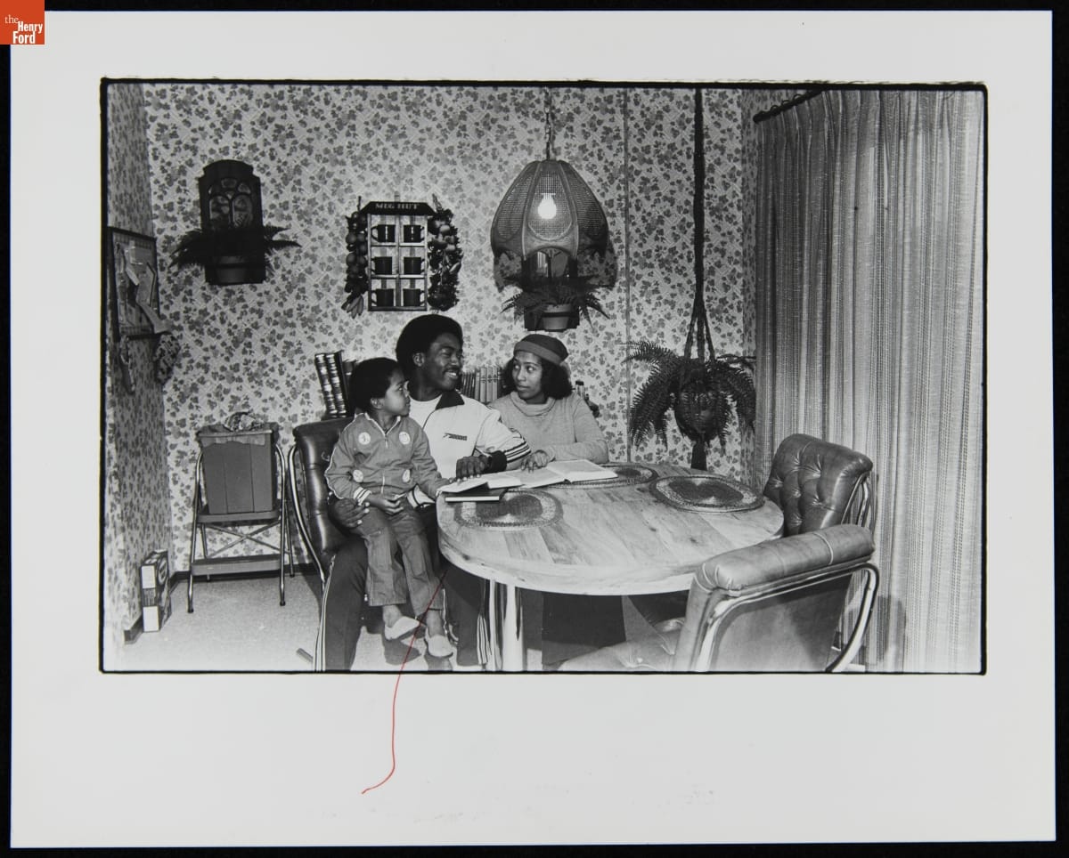 Chet Lemon with His Wife, Valerie Jones, and Son, Chet, Jr. Sitting at their Dining Room Table, December 1981 Black man, woman, and child sitting at a table with books in front of them and on a small shelf behind them