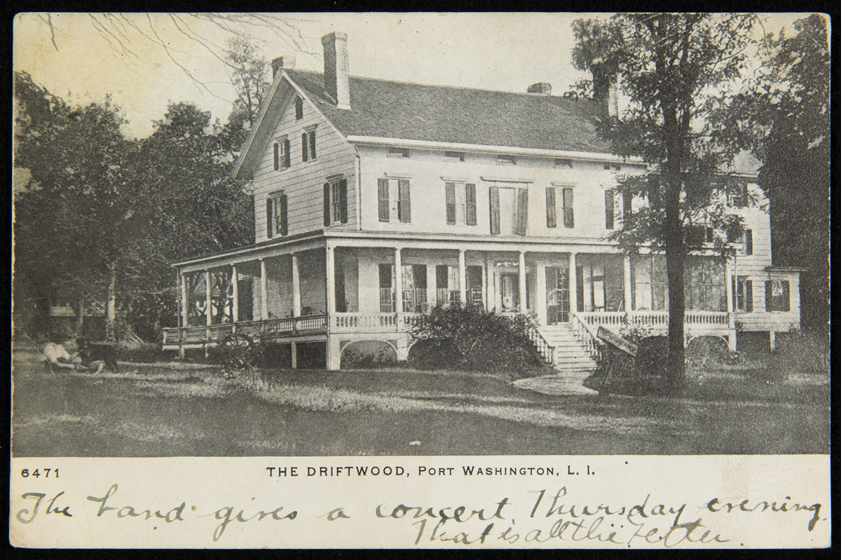 Large, two-story wooden house with wrap-around porch; also contains printed and hand-written text