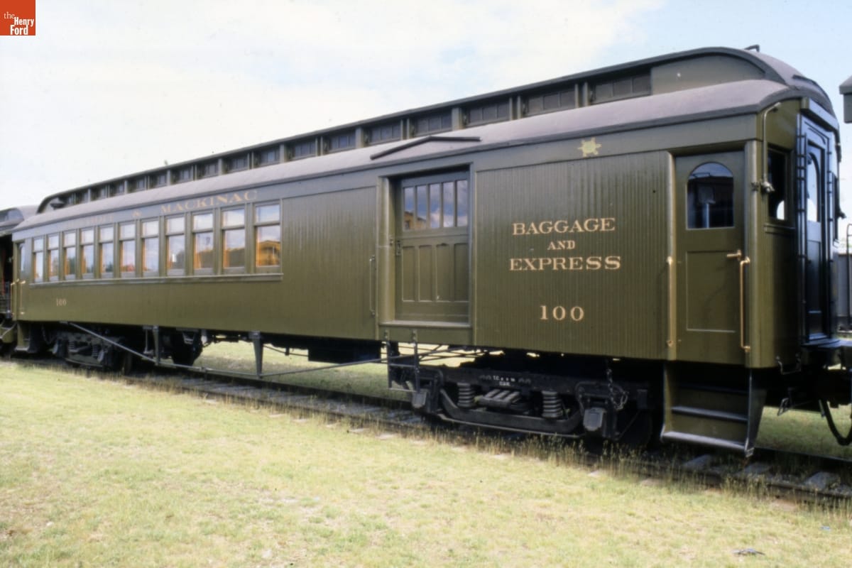Army green railroad car on railroad tracks