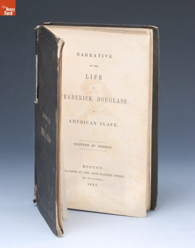 Book standing on end, open to title page containing text