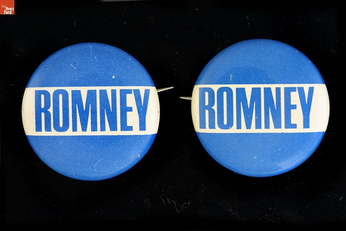 Two circular blue buttons with wide white band containing blue text “ROMNEY” across center
