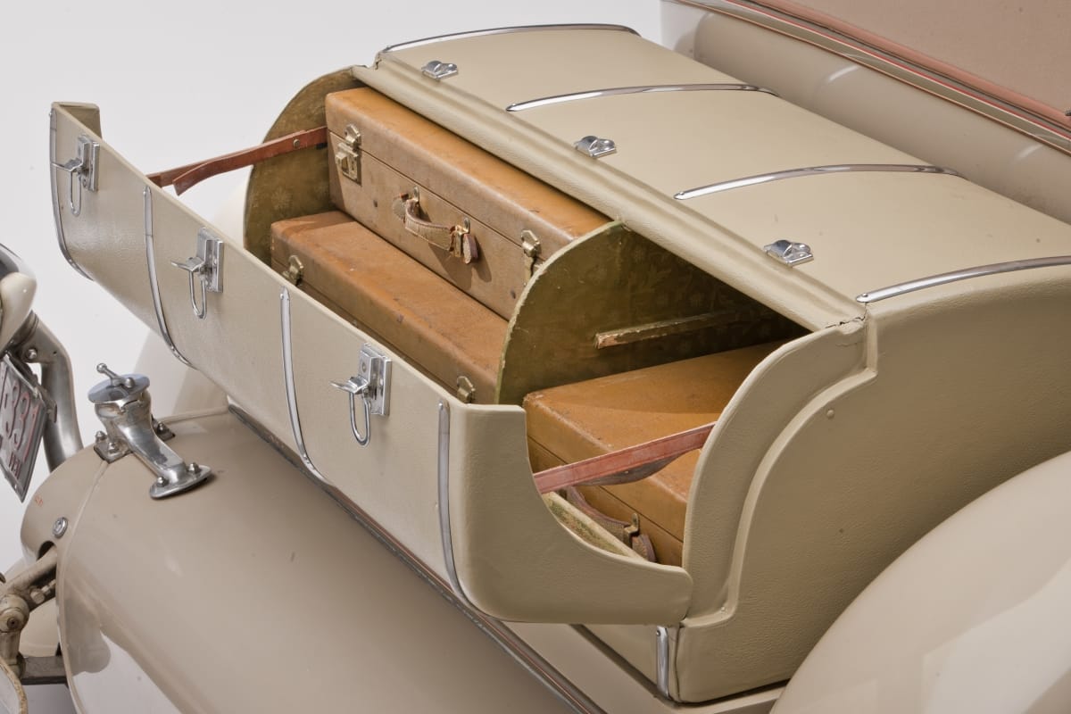 Rounded car trunk, opened to show luggage fitted snugly into two compartments