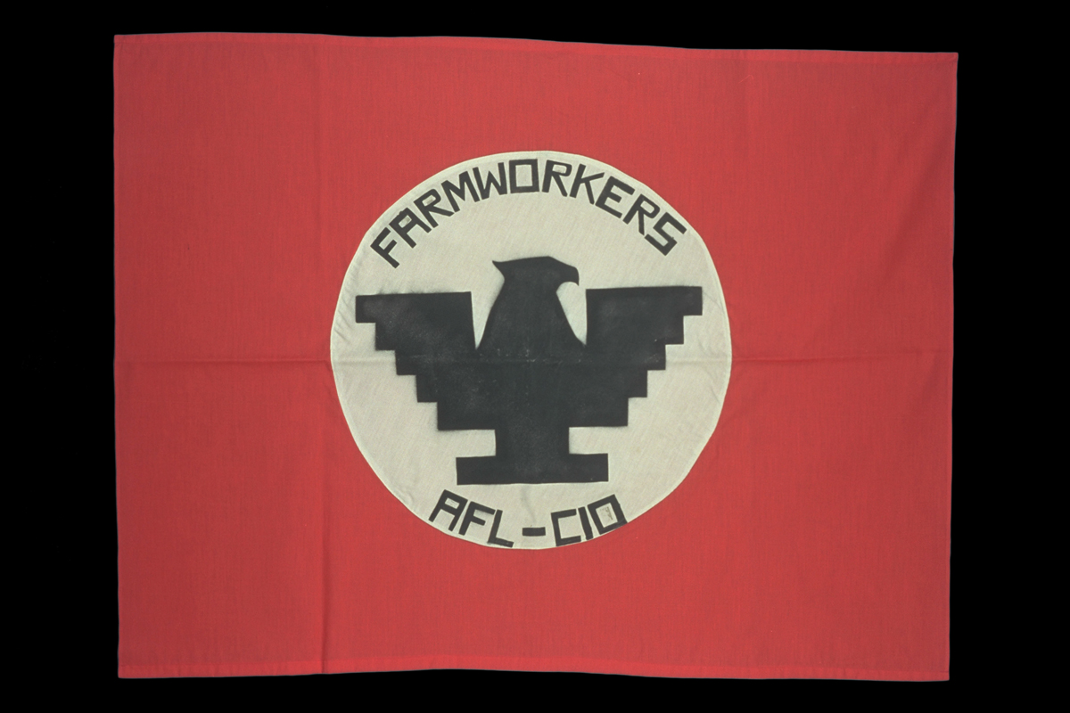 Red flag with white circle in middle containing stylized black eagle and text 