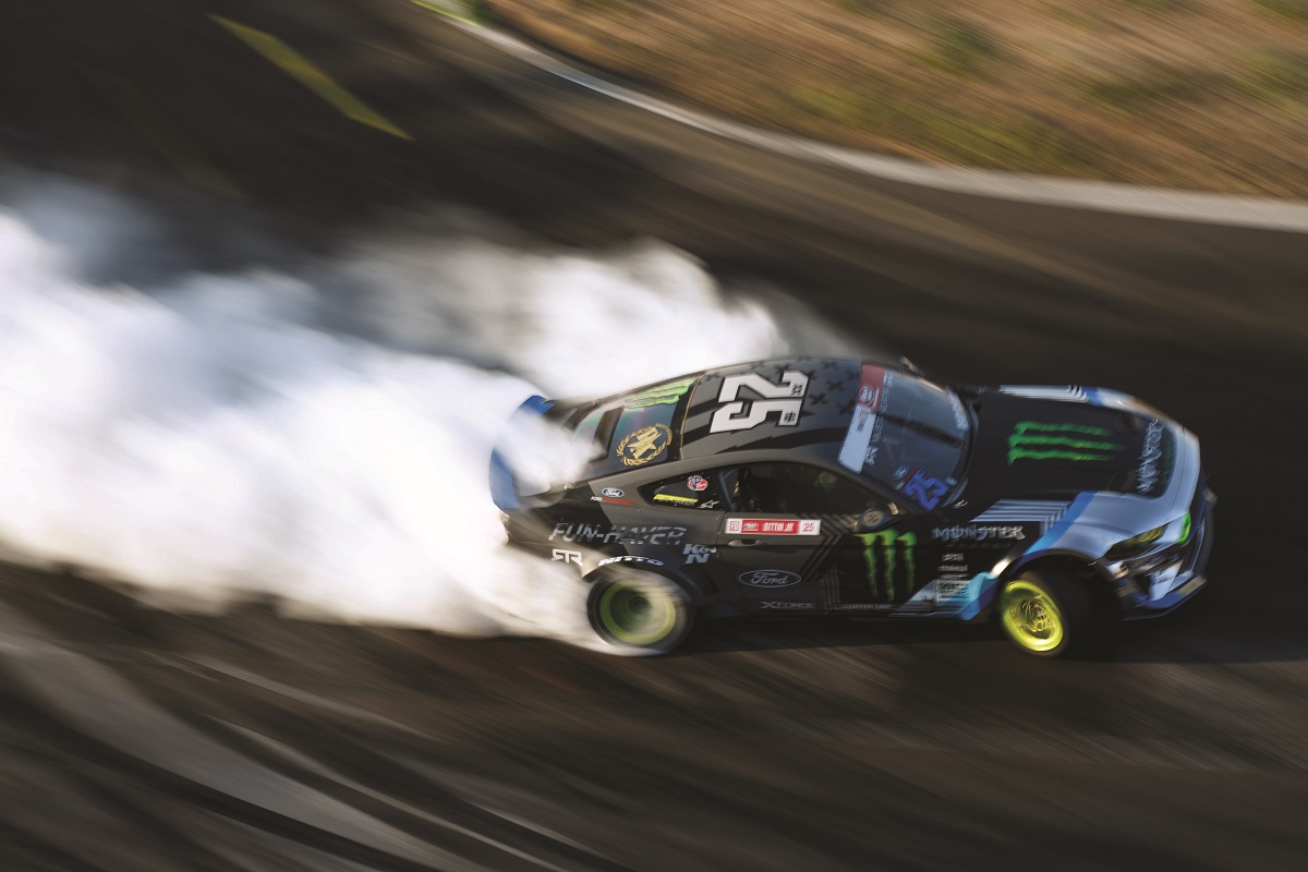 Vaughn Gittin, Jr., in his No. 25 Mustang during the 2019 Formula Drift championship series Aerial shot of gray race car with text and logos turning on racetrack and trailing smoke